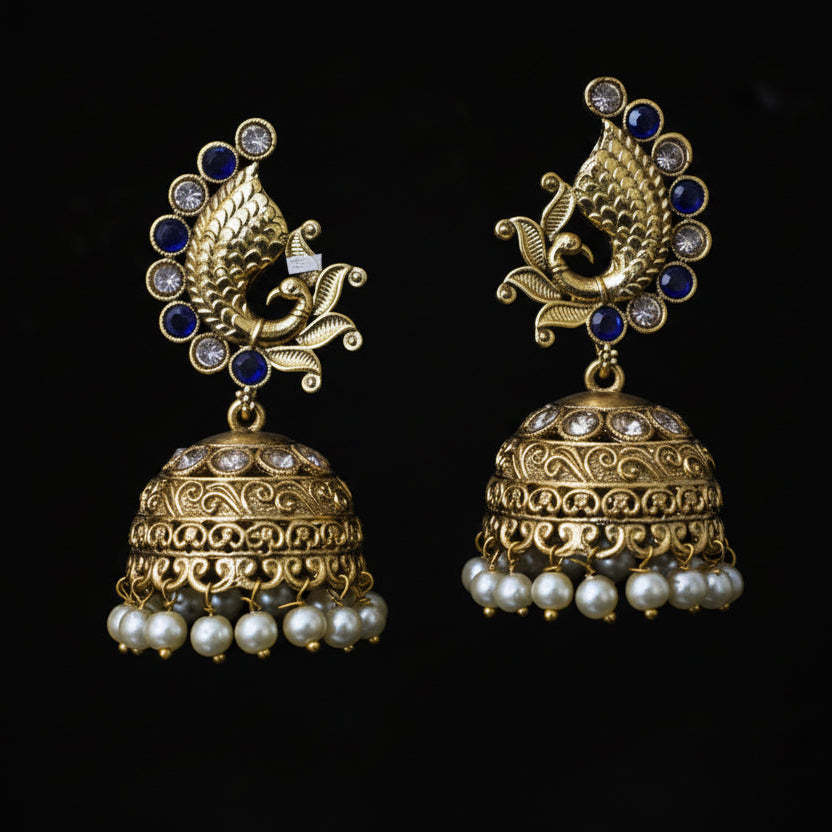 Gold and pearl earrings on a gray 'Y' shaped stand with 'SAHELI' branding.