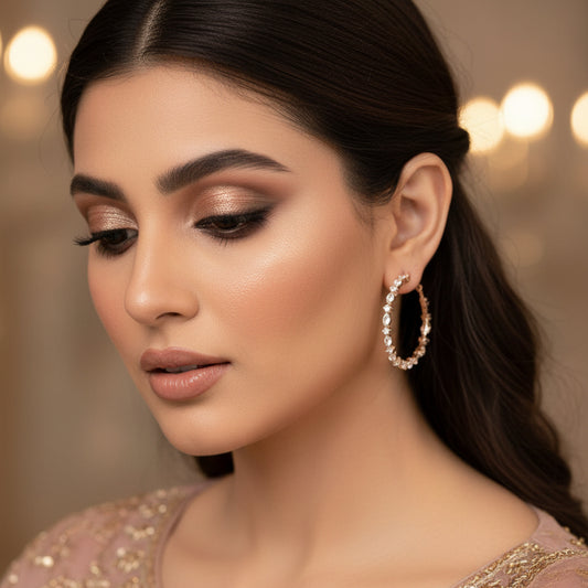 Pair of diamond earrings on a gray stand with 'SAHELI' branding.