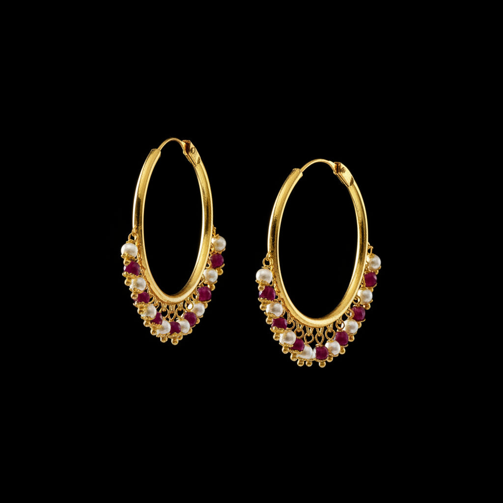 A pair of gold-plated hoop earrings with dangling pearl-like white beads and small maroon-red beads, displayed on a gray textured surface with the brand logo 'SAHELI MY BEST FRIEND' above them.