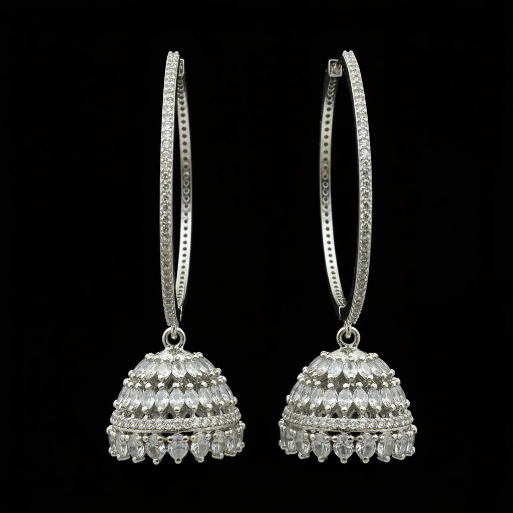 Silver hoop earrings on a black stand with 'Saheli' branding.