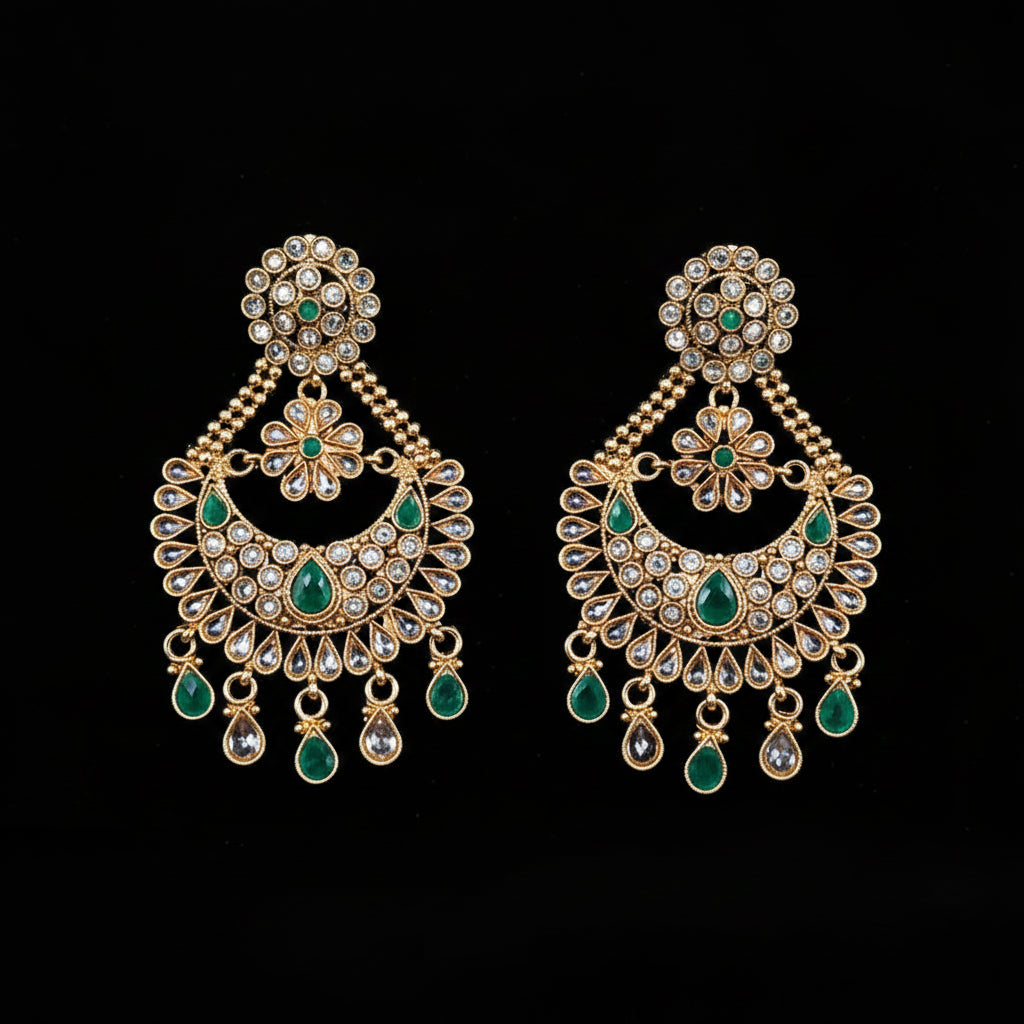 A pair of gold-toned Indian chandelier earrings with green stone accents and clear crystal-like stones, displayed on a black background with the brand logo 'SAHELI MY BEST FRIEND' at the top.