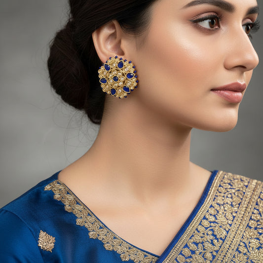 Gold and blue earrings on a gray background with 'Saheeli' branding.