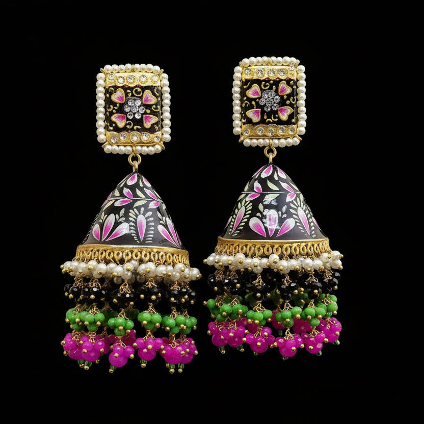 Ornate earrings with intricate designs on a gray background, featuring the brand 'SAHELI'.