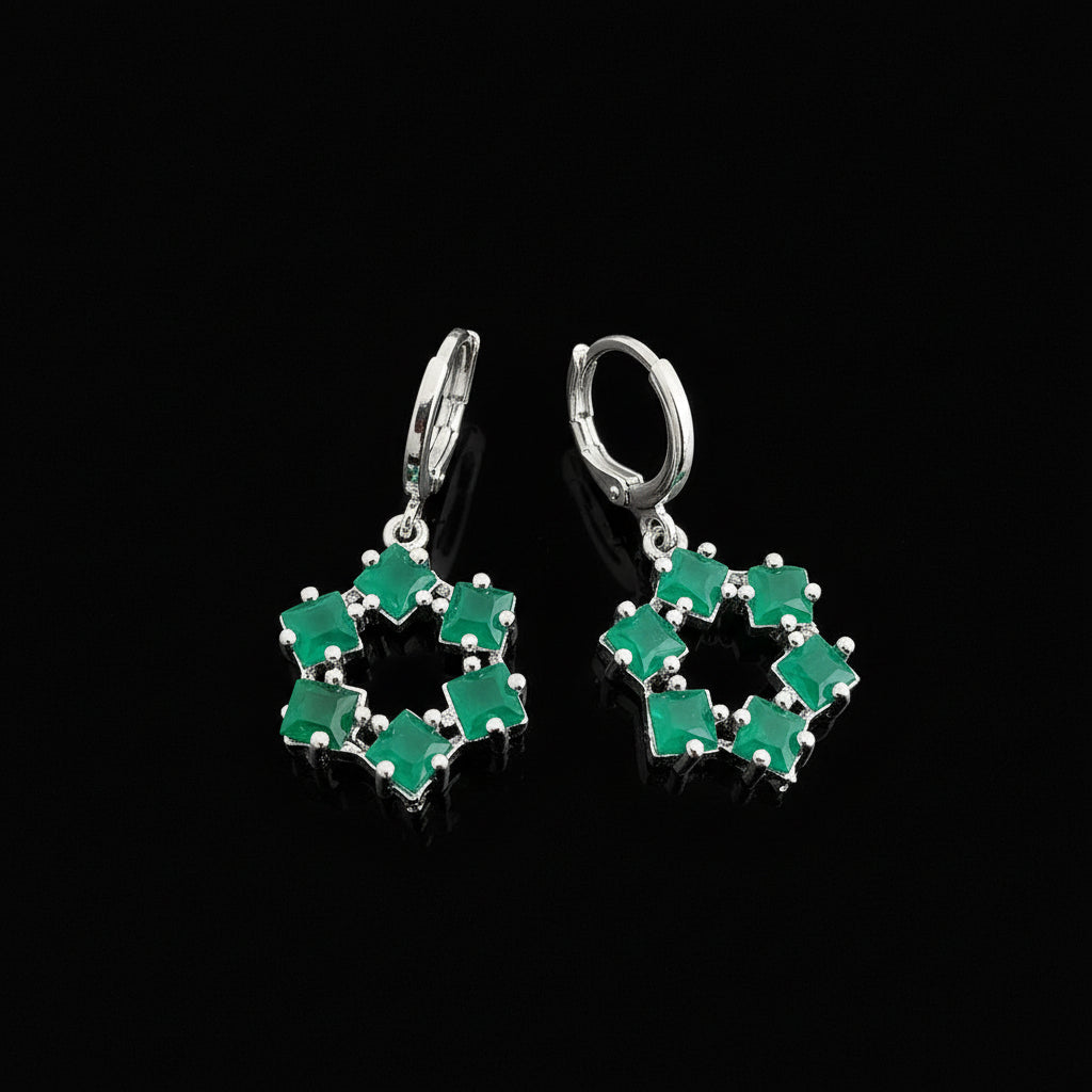 Pair of green gemstone earrings on a gray background with 'Saheli' branding.