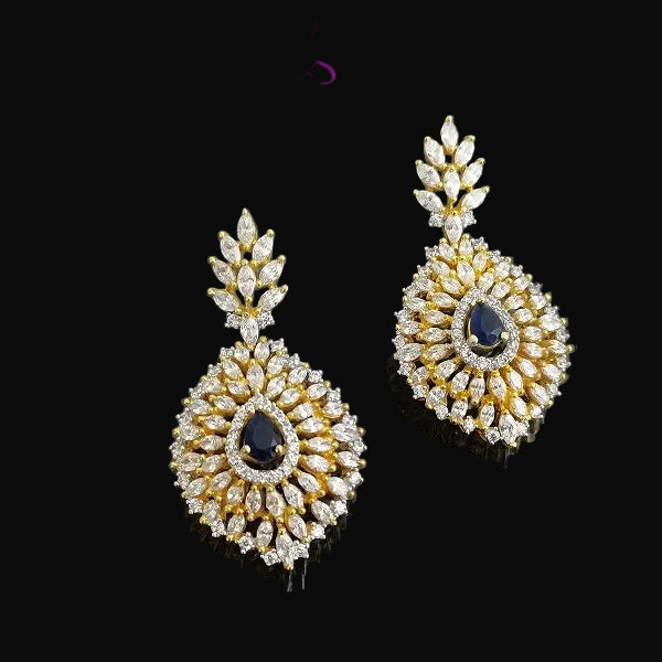 Gold and diamond earrings with a black gemstone on a dark background, branded 'SAHELLI'.