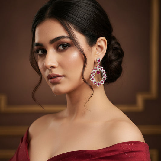 Pair of earrings with pink gemstones on a gray background