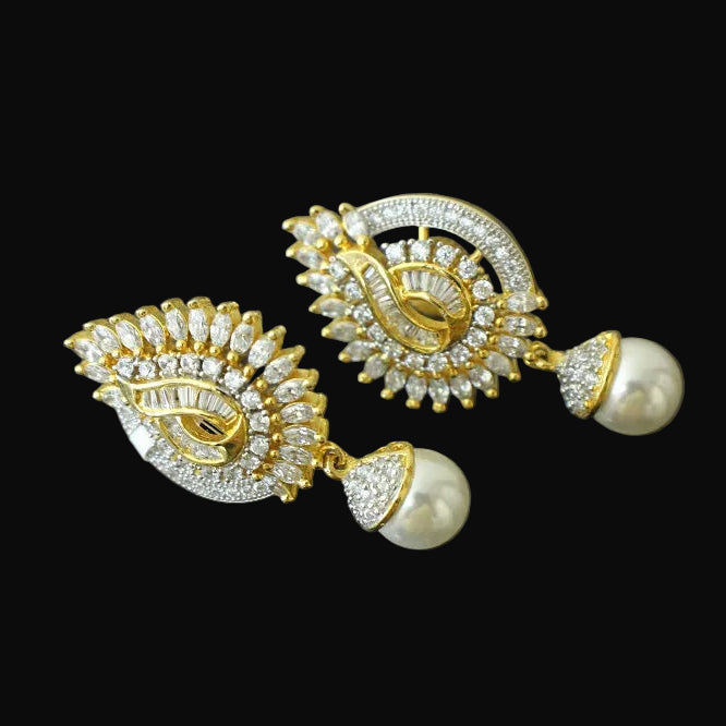 Gold and pearl earrings on a dark background with 'Saheli' branding.