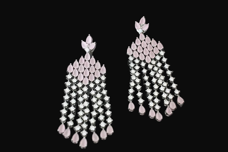 Pair of pink and silver chandelier earrings on a dark background