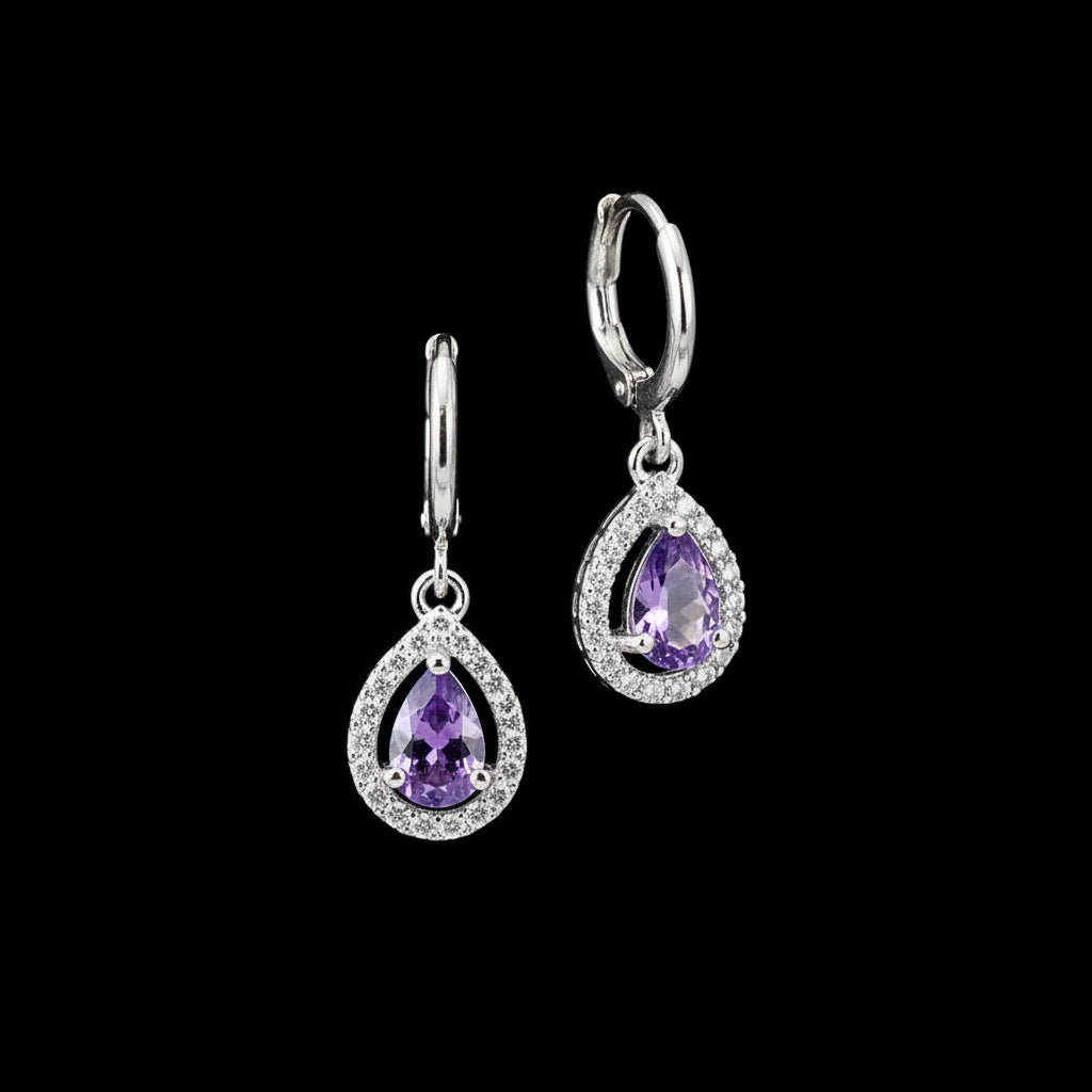 Silver earrings with purple gemstones on a gray background, branded 'Saheli'.