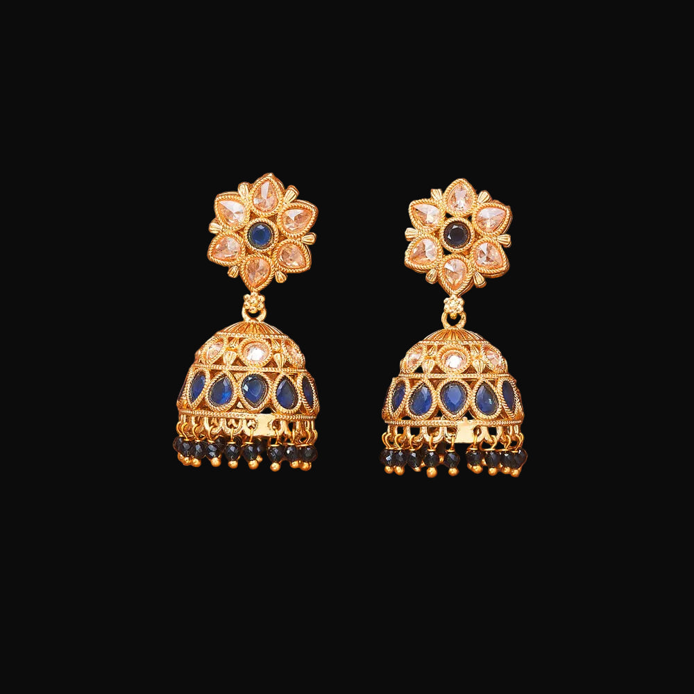 Pair of gold and blue earrings on a brown background