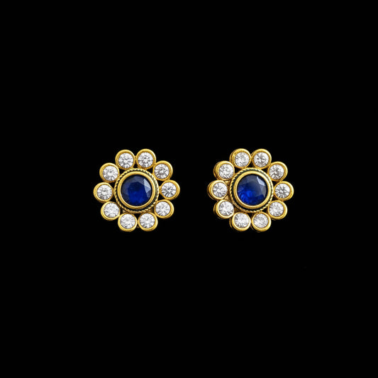 Gold and blue earrings with 'SAHELI' branding on a gray background