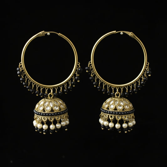 Pair of gold hoop earrings with pearl drops on a black background