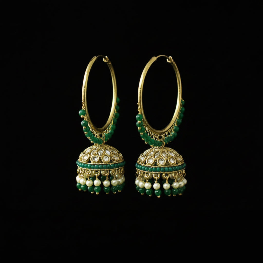 Pair of gold hoop earrings with green and pearl accents on a black stand.