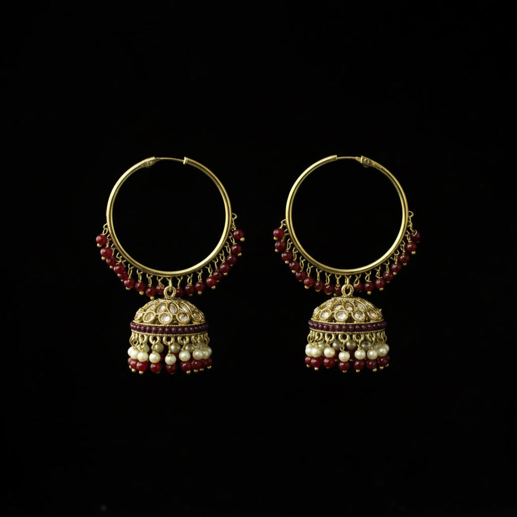 Pair of gold hoop earrings with red and white beads on a black background