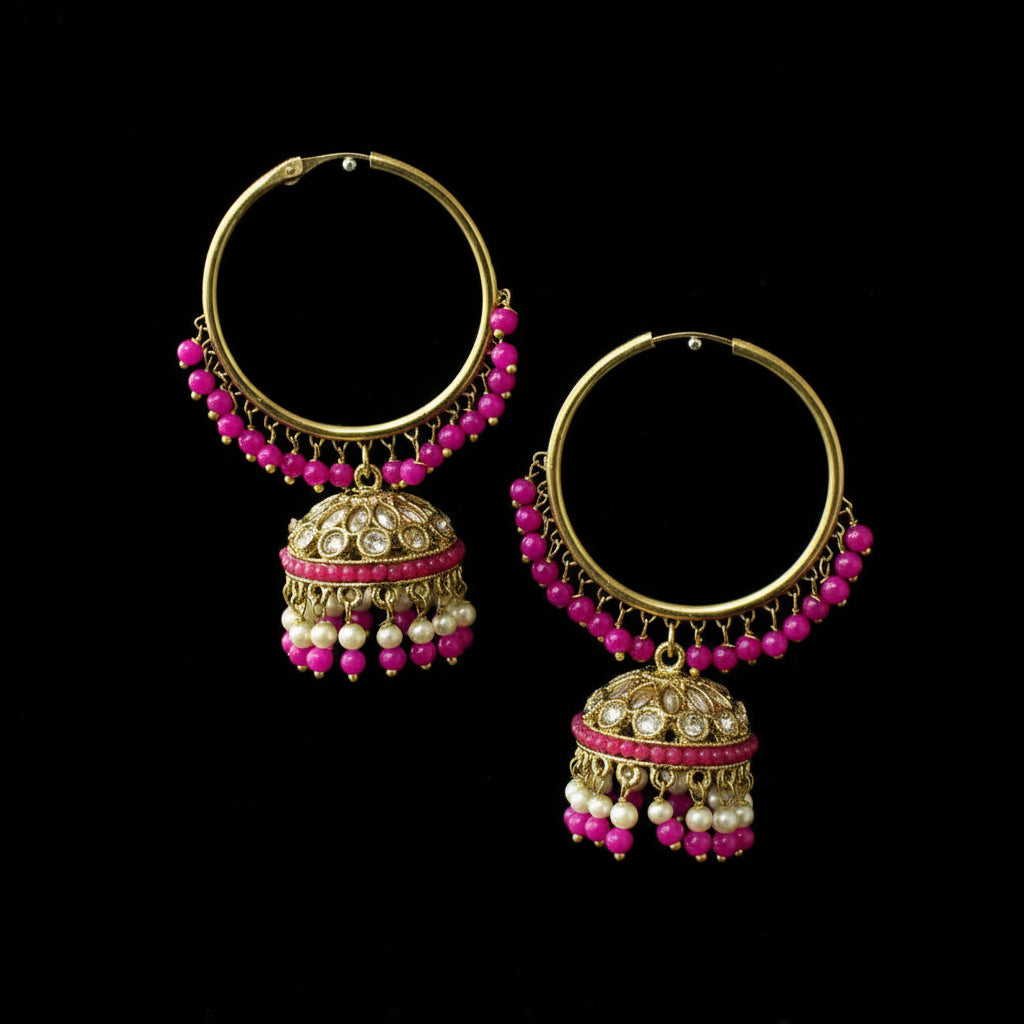 Pair of gold hoop earrings with pink beads on a black stand