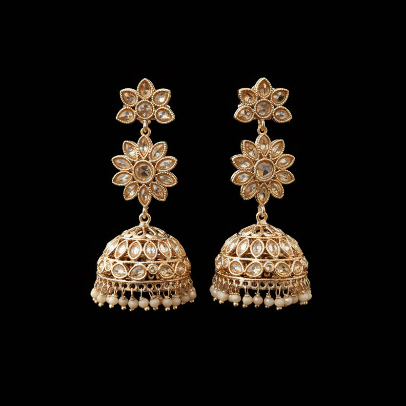 Gold floral earrings on a gray stand with 'SAHELL' branding.