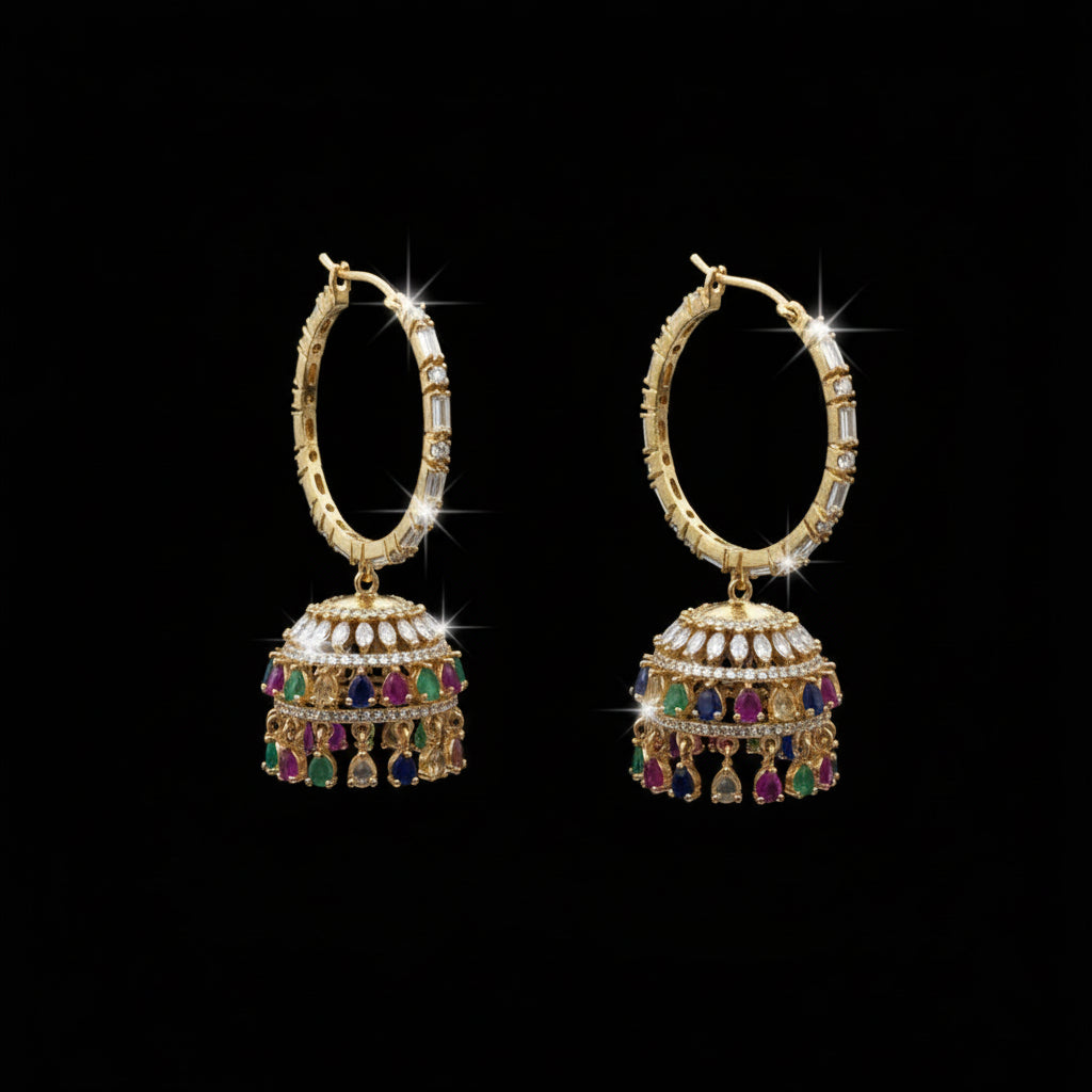 Ornate gold earrings with gemstones on a black stand against a gray background