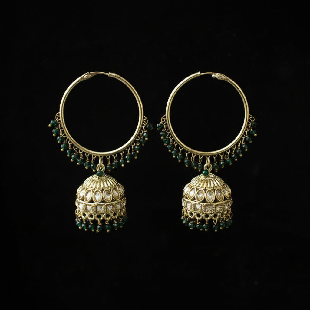 Pair of gold hoop earrings with green gemstones on a black background