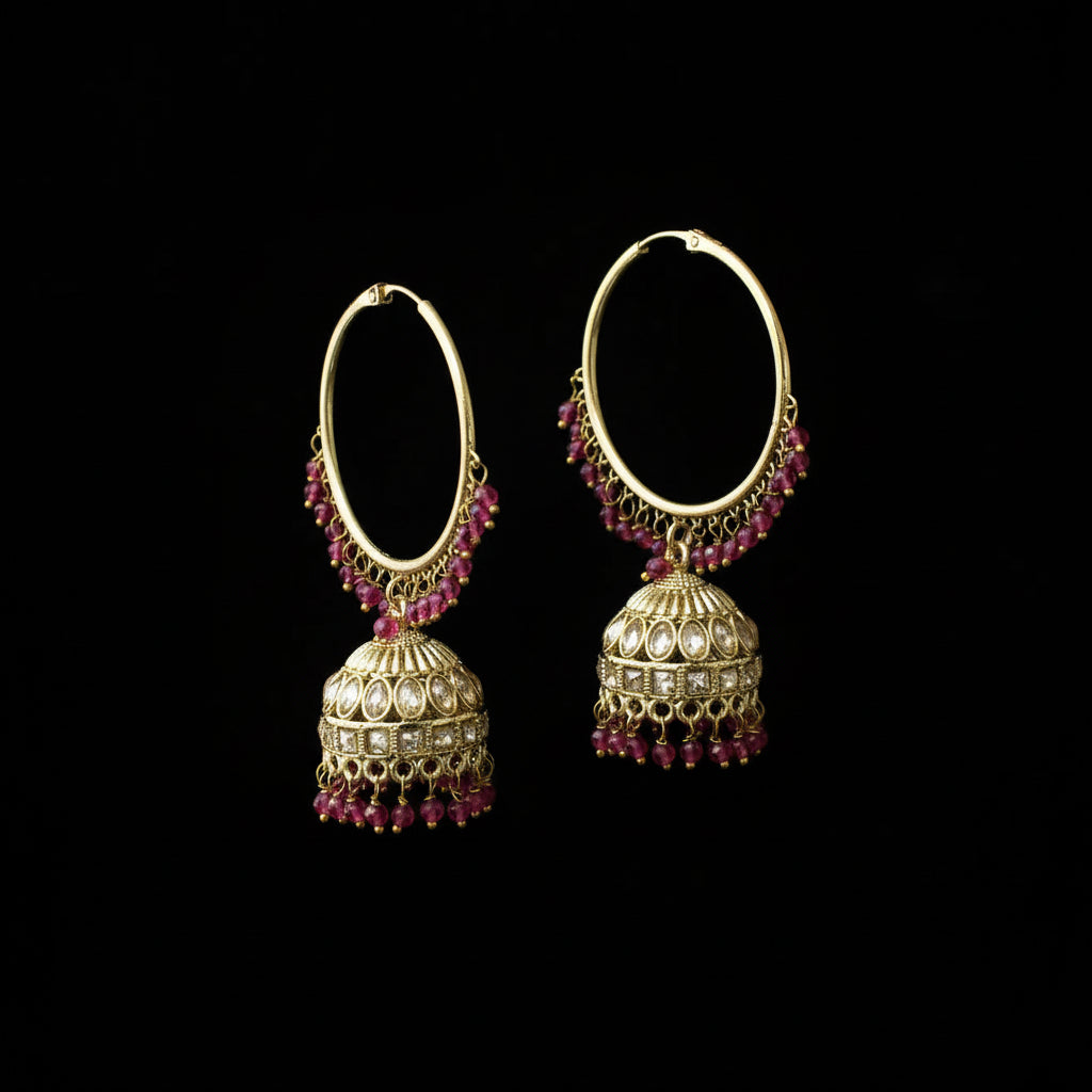 Gold hoop earrings with red gemstones on a black background