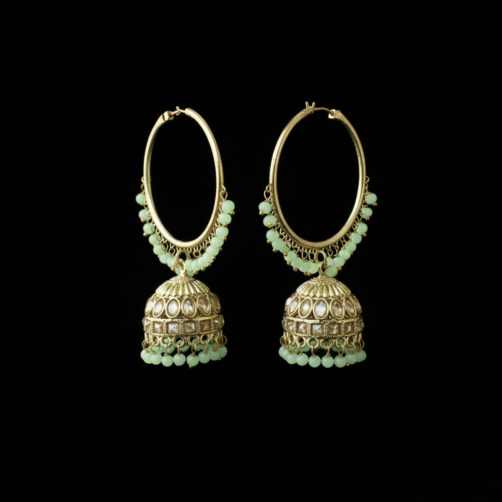 Pair of gold hoop earrings with green beads on a black background