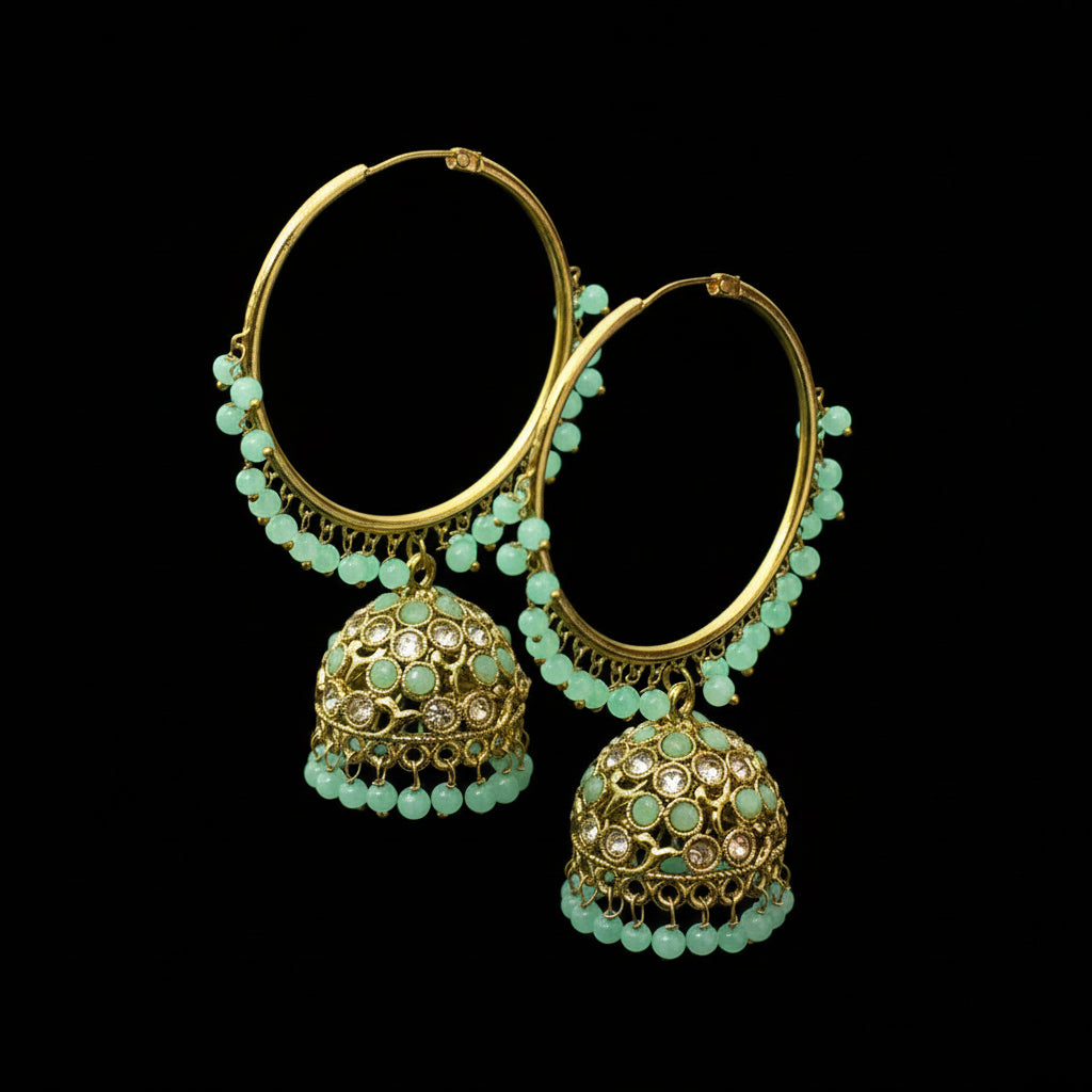 Gold and green beaded earrings on a black stand with 'SAHELLI' branding.