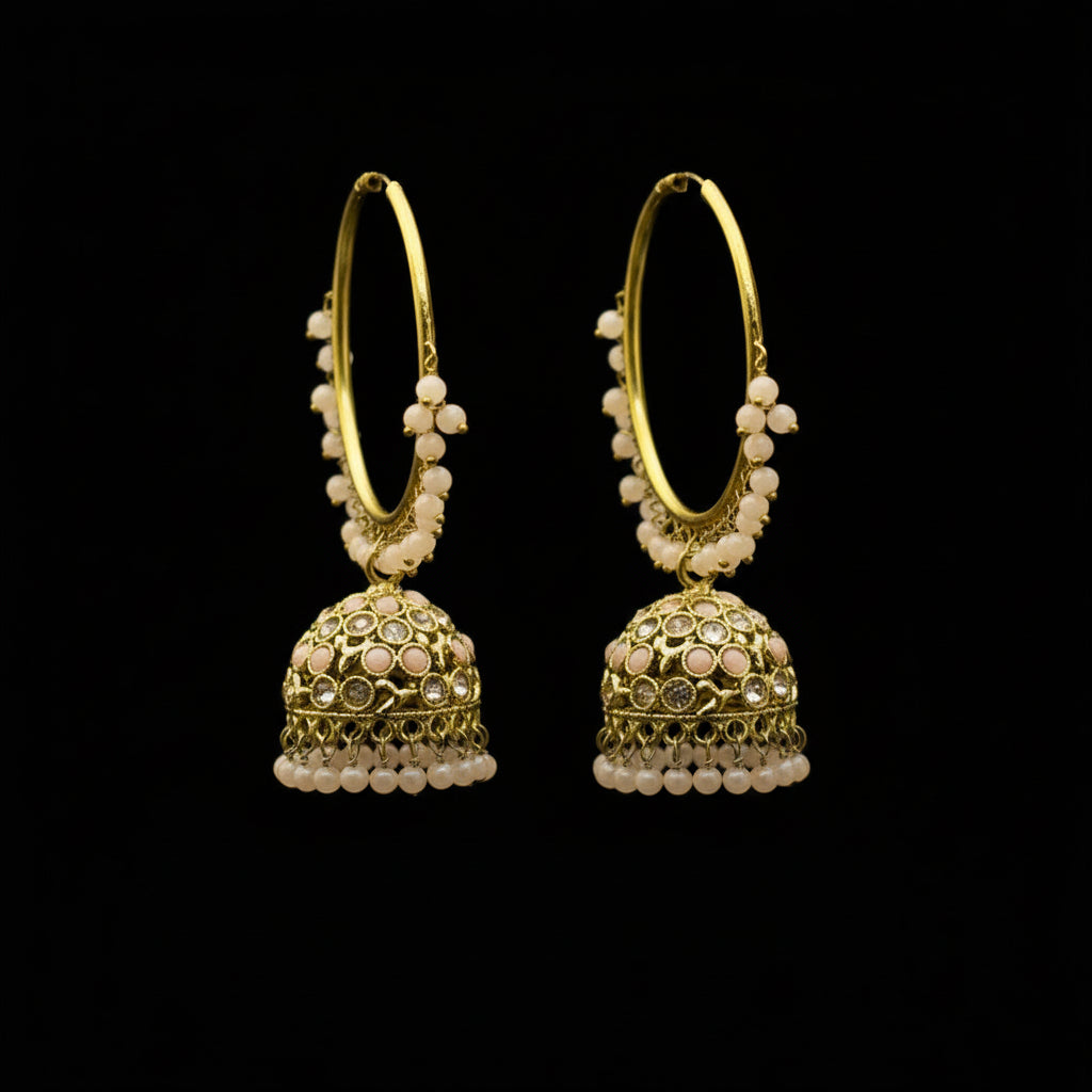 Gold hoop earrings with spherical embellishments on a black stand against a gray background.