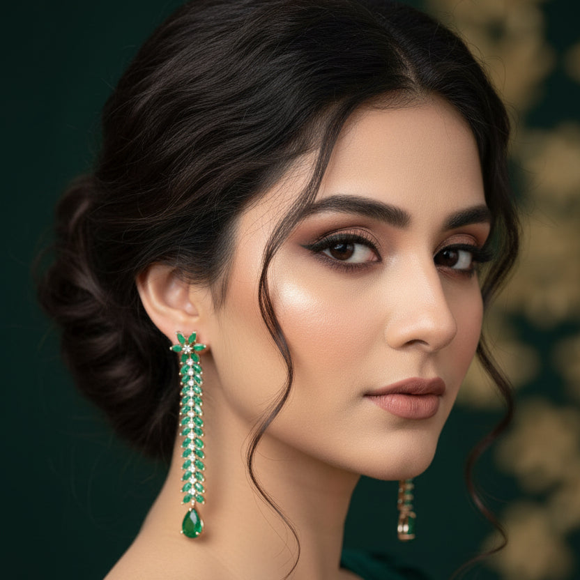 Pair of green emerald earrings on a dark gray background