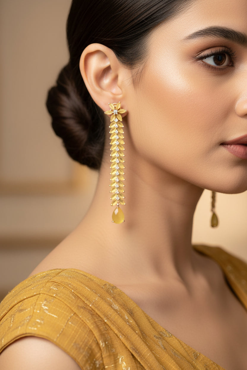 Pair of gold floral earrings on a dark background