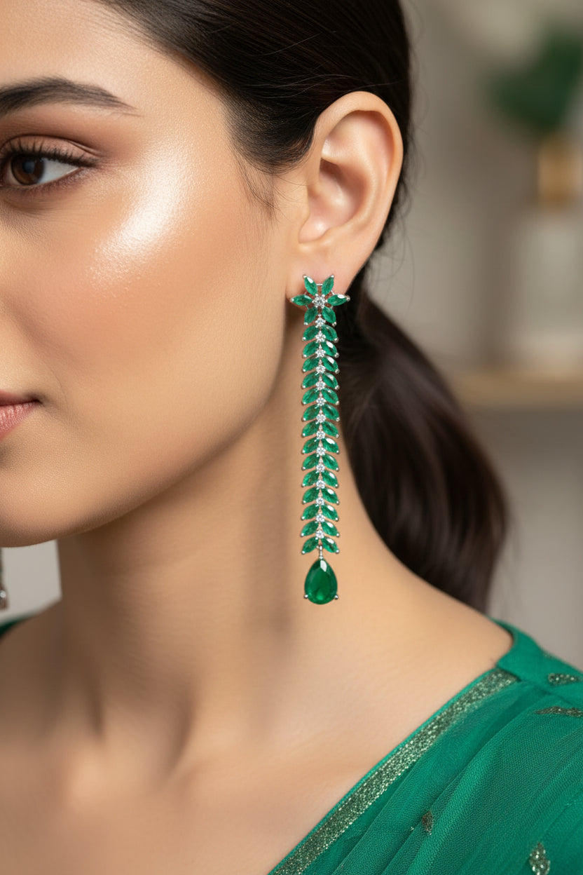 Pair of green emerald earrings on a dark background