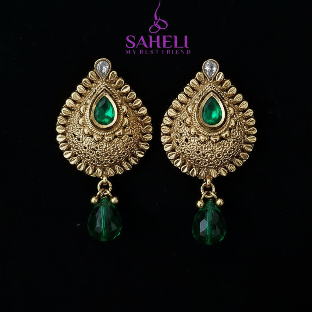 Gold earrings with blue stones on a black background, featuring the brand 'Saheli'.