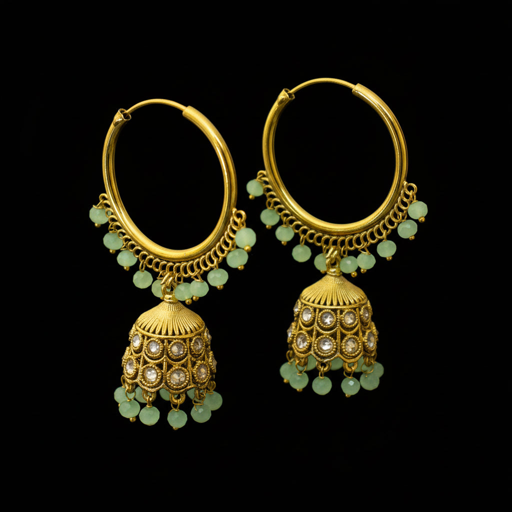 Gold hoop earrings with green gemstones on a black stand