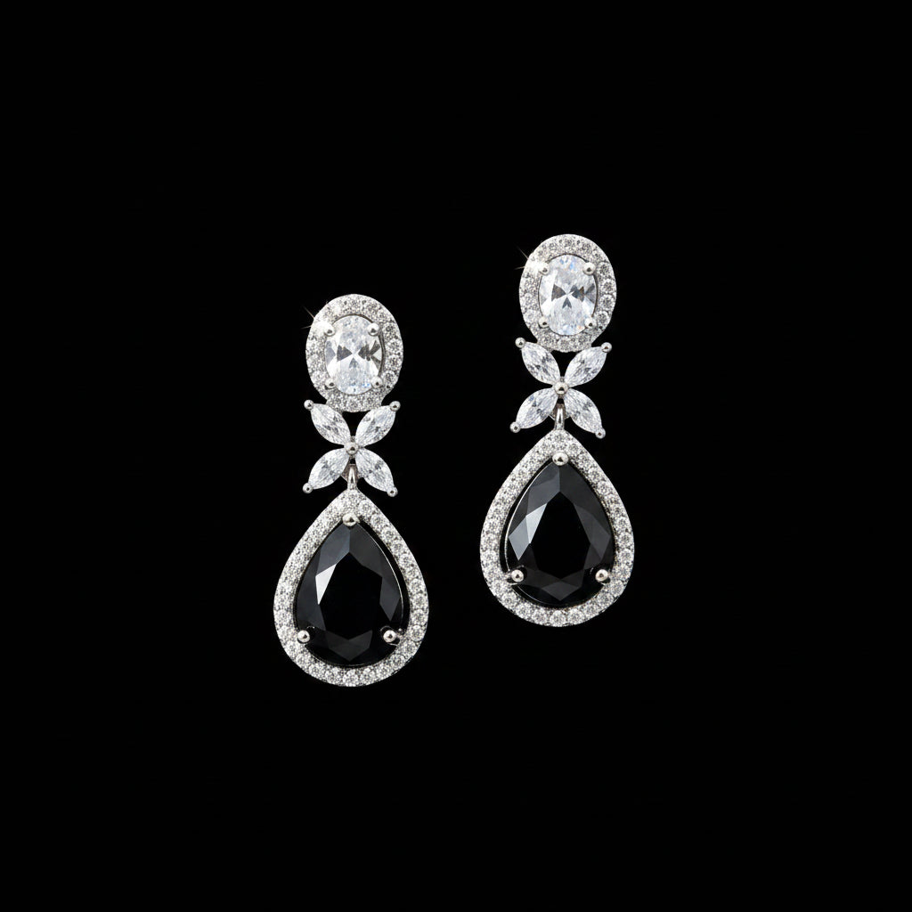 Pair of teardrop-shaped earrings with gemstones on a dark background