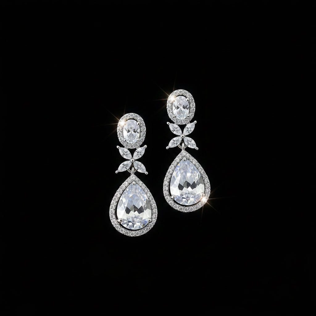 Pair of teardrop-shaped earrings with clear stones on a dark background