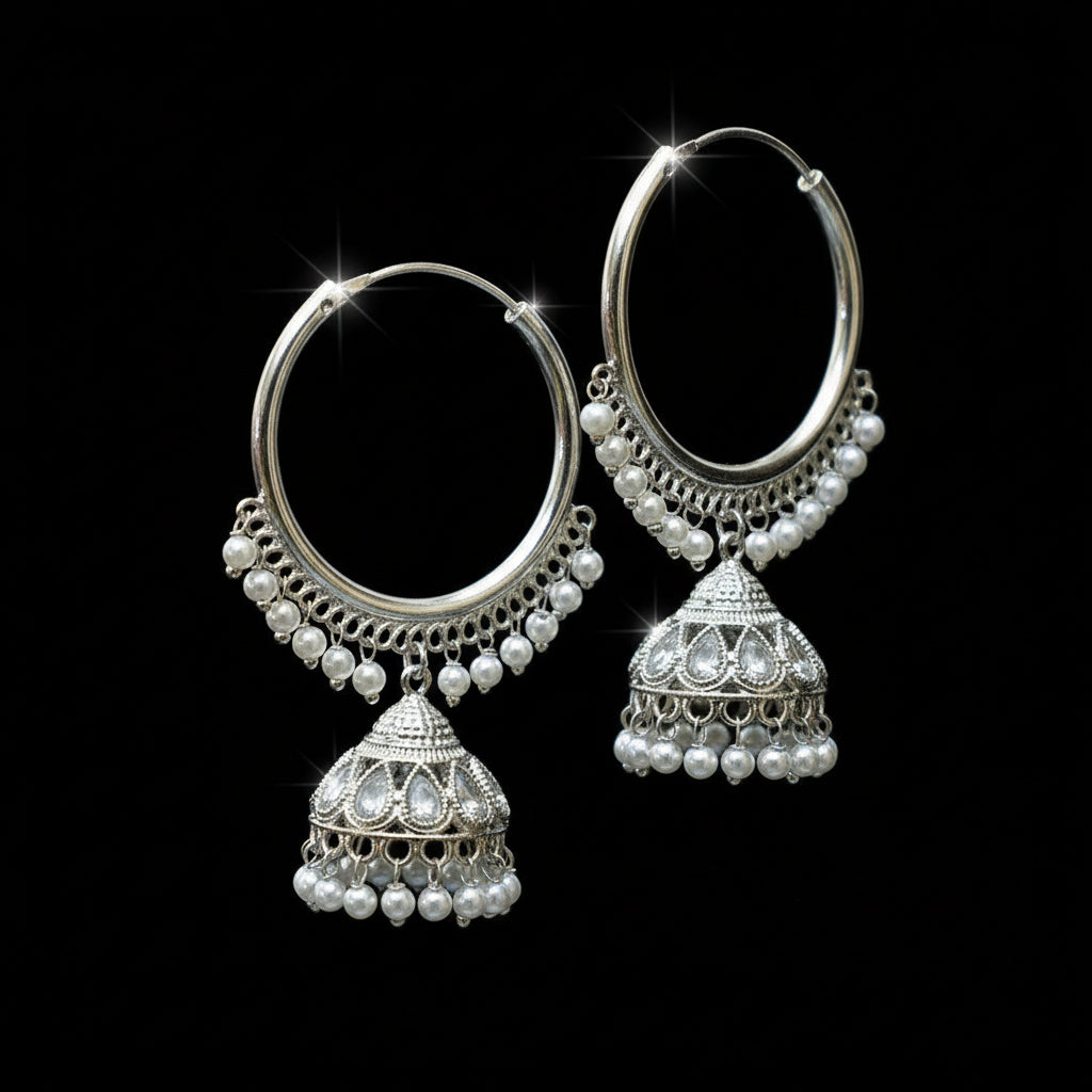 Silver hoop earrings with pearl accents on a black stand against a gray background