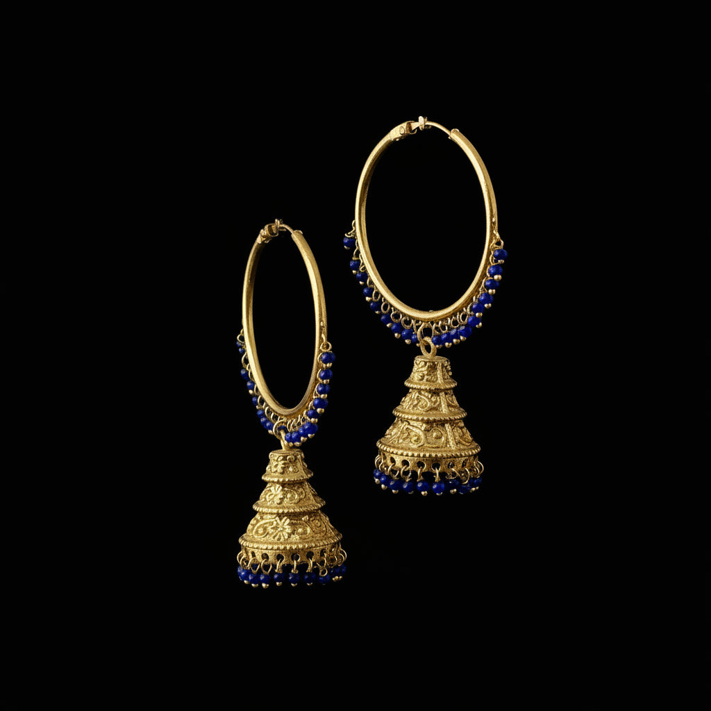 Gold and blue beaded earrings on a black stand with 'SAHELI' branding.