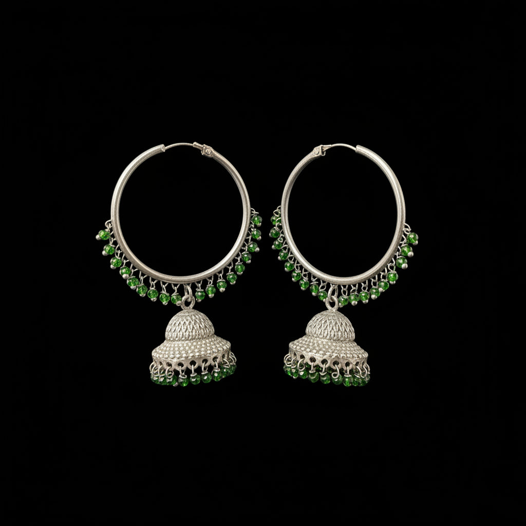 Silver hoop earrings with green beads on a gray background, featuring the brand 'SAHELI'.