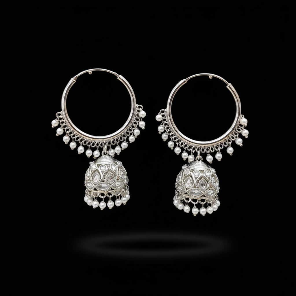 Silver hoop earrings with pearl drops on a gray background, branded 'Saheli'.