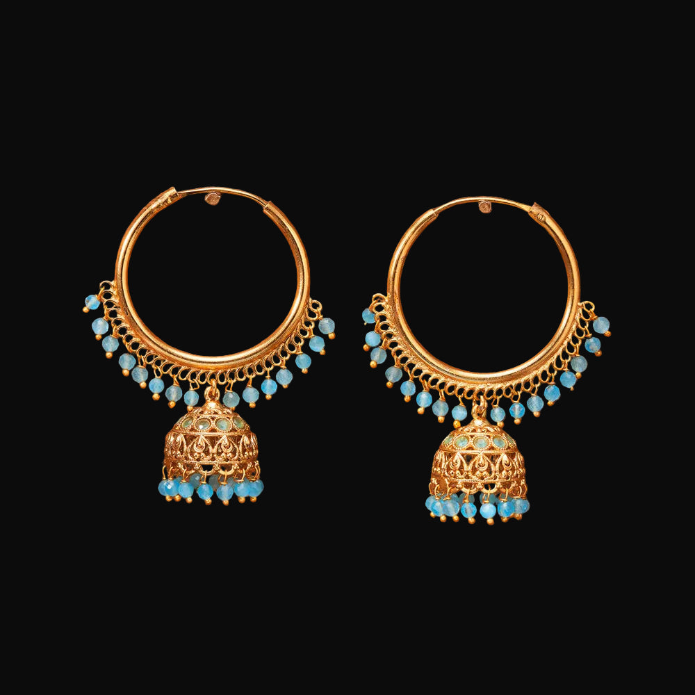 Gold hoop earrings with turquoise beads on a brown background