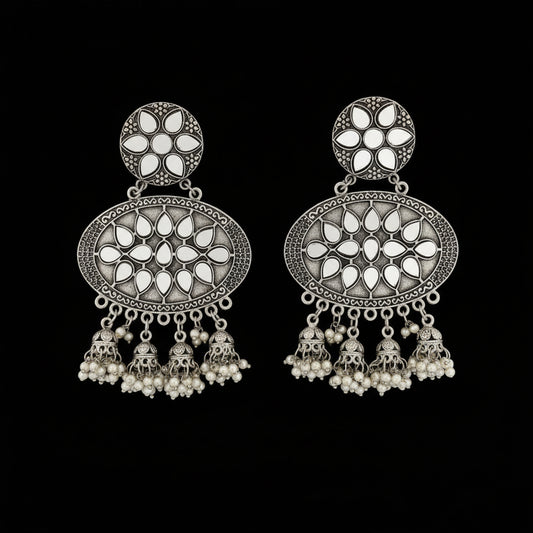 Ornate silver earrings with pearl-like stones on a dark background, featuring the brand 'Sahell'.