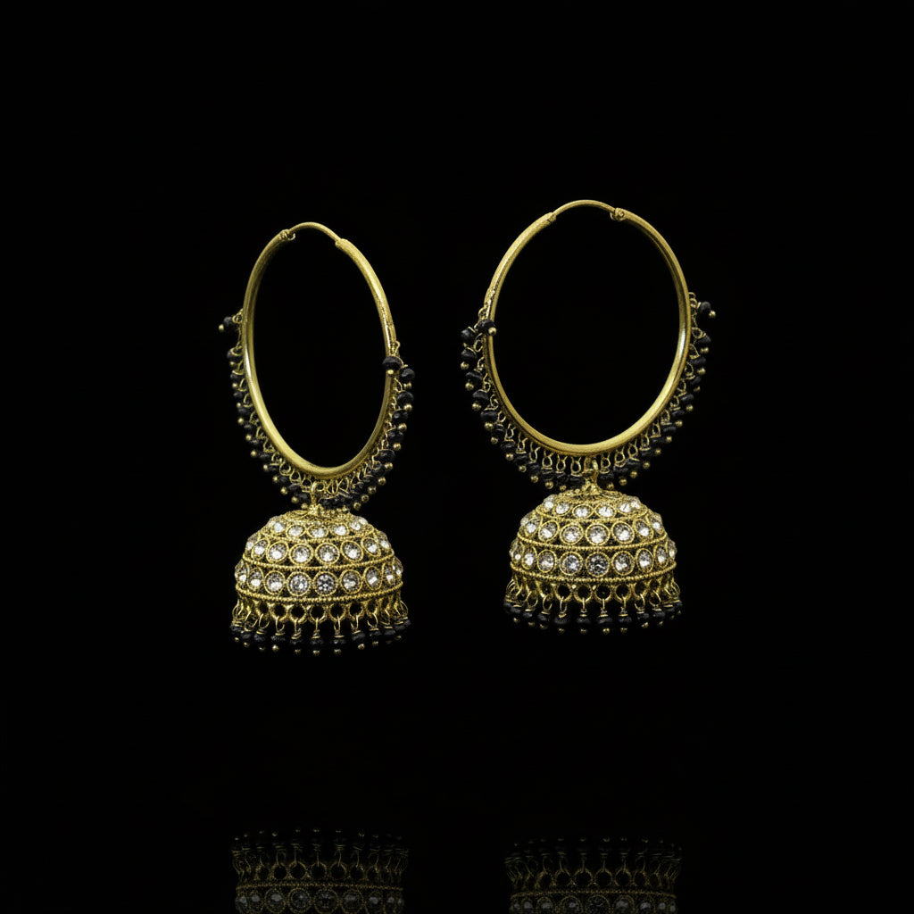 Gold hoop earrings with spherical embellishments on a black stand, branded 'SAHELLI'.
