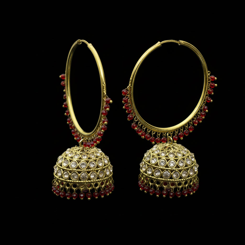 Gold and red earrings on a black stand with 'SAHELI' branding.