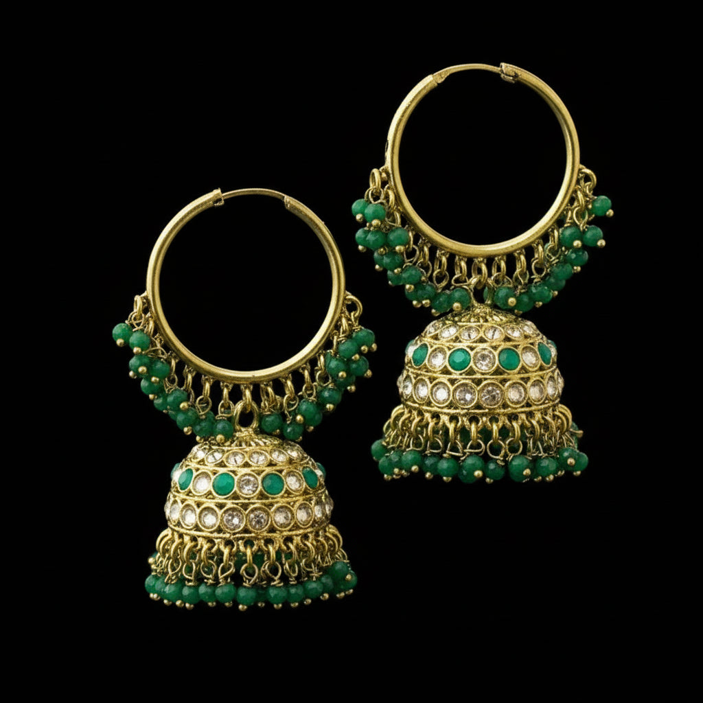 Gold and green beaded earrings on a black stand with 'Saheli' branding.