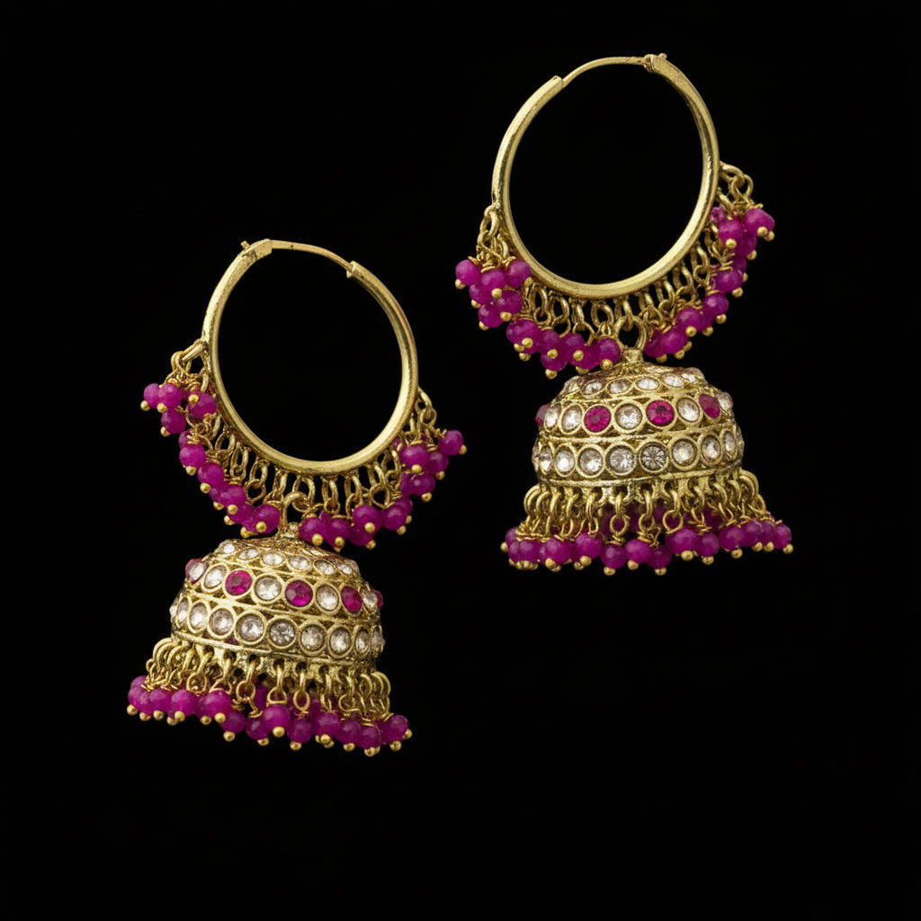 Gold and pink beaded earrings on a black stand with 'Saheli' branding.