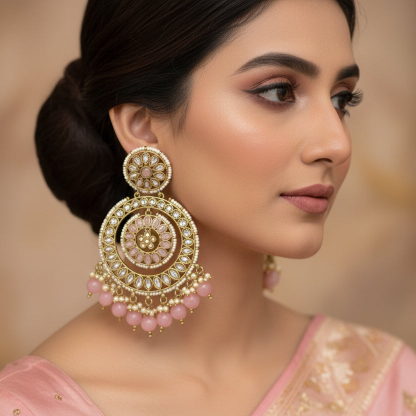Ornate earrings with pink beads on a dark background, branded 'Saheli'.