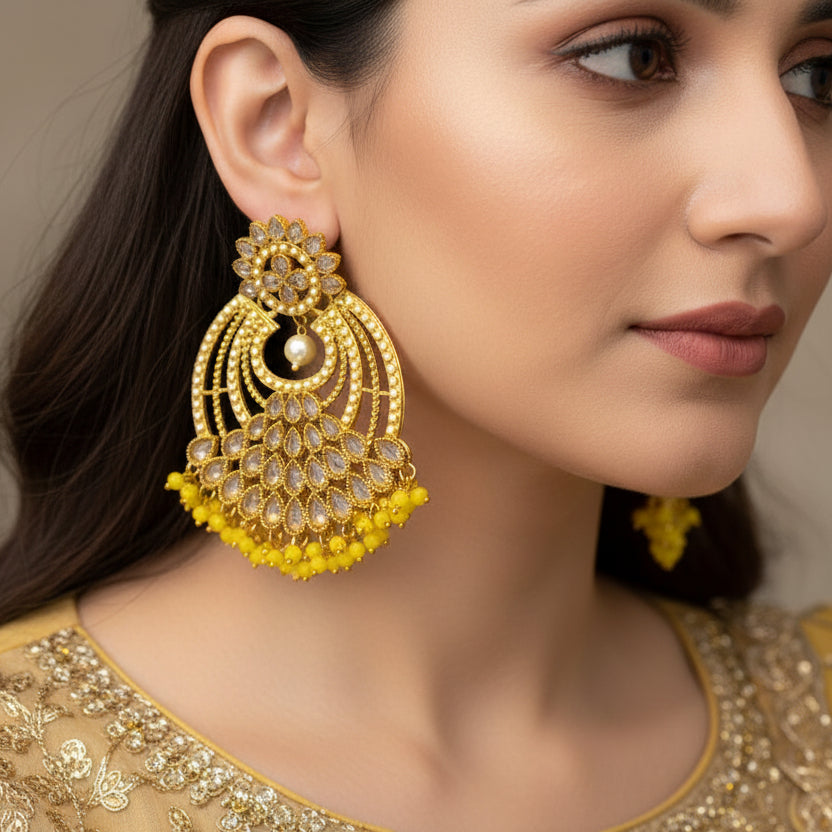 Gold and yellow earrings on a gray background