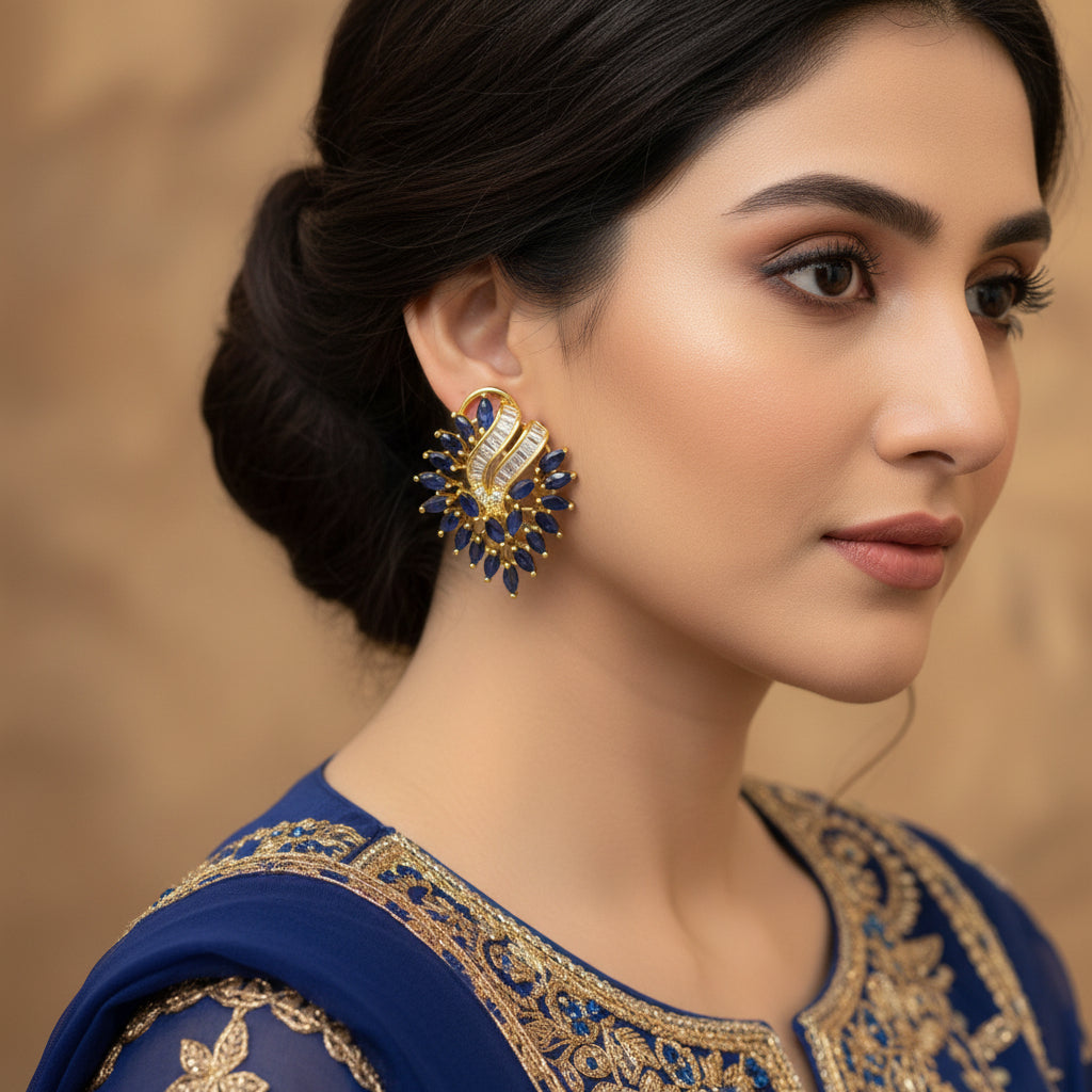 Pair of gold and blue earrings on a dark background with 'SAHELI' branding.