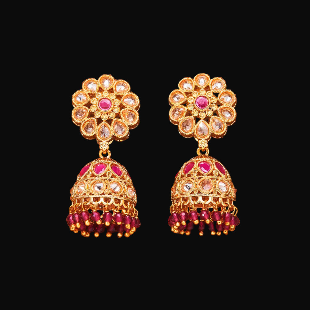 Gold and red beaded earrings on a brown background