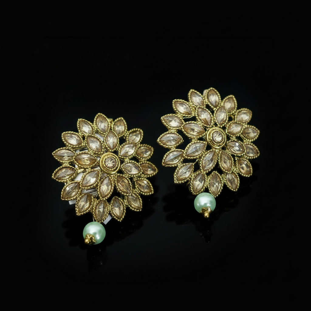 Pair of gold and pearl earrings on a dark gray background