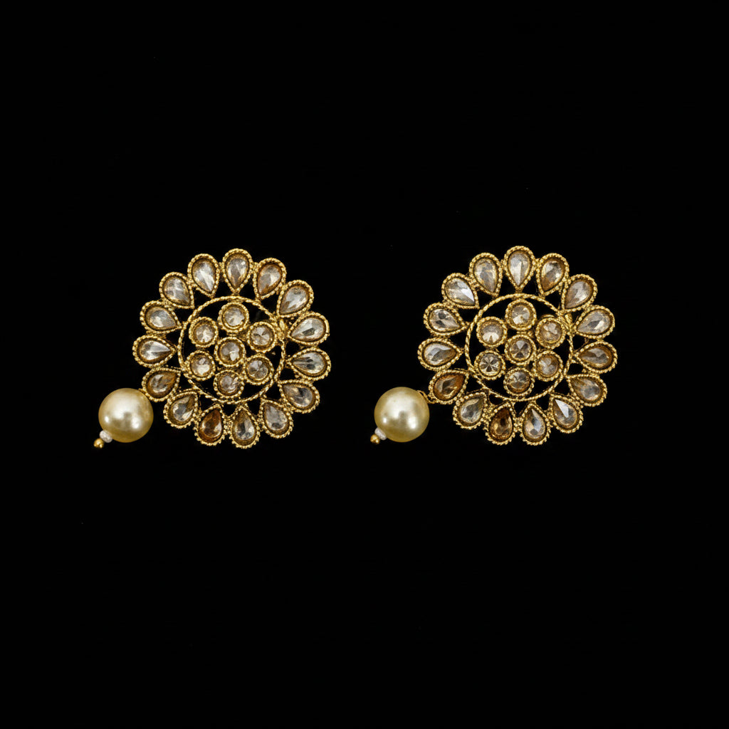 Pair of gold and pearl earrings on a dark gray background