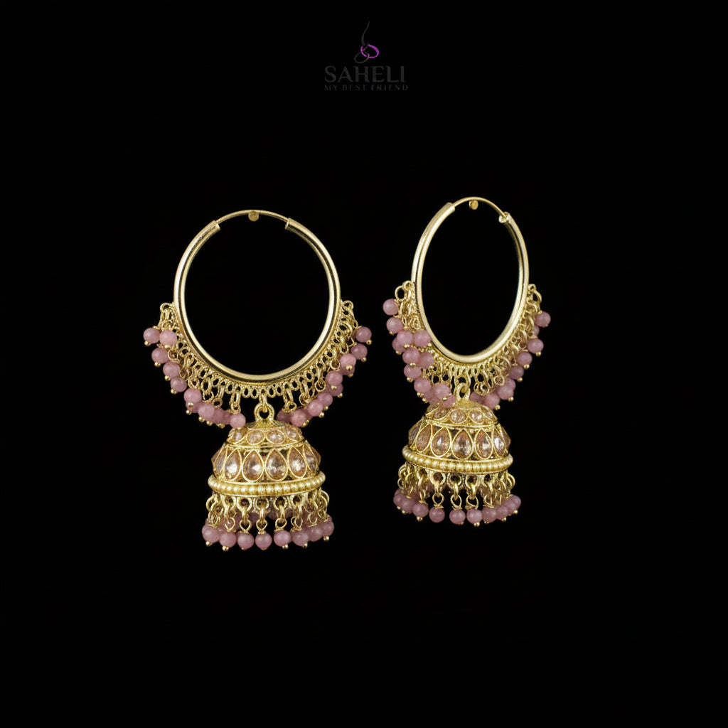 Gold hoop earrings with pink beads on black stands, branded 'Saheili'.